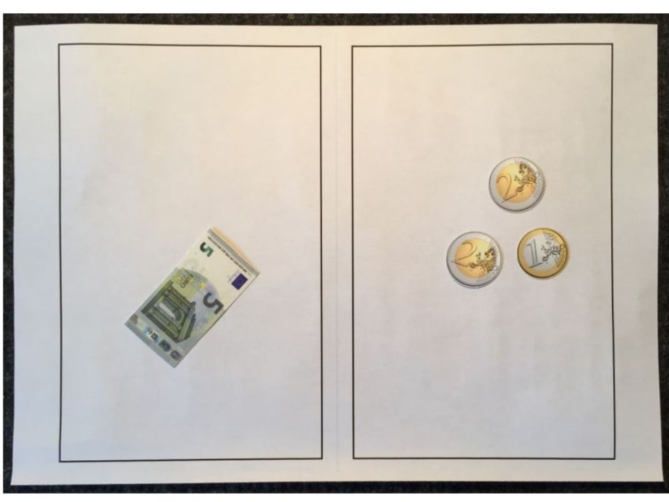 Foto einer Lernumgebung zur Größenvorstellung von Geldwerten. Links: ein 5 Euroschein, Rechts: 2 Zweieurostücke und 1 Eineurostück.